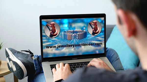 Laptop displaying example of jewellery and auctioneer gavel jewelleryauctioneer.com is for sale